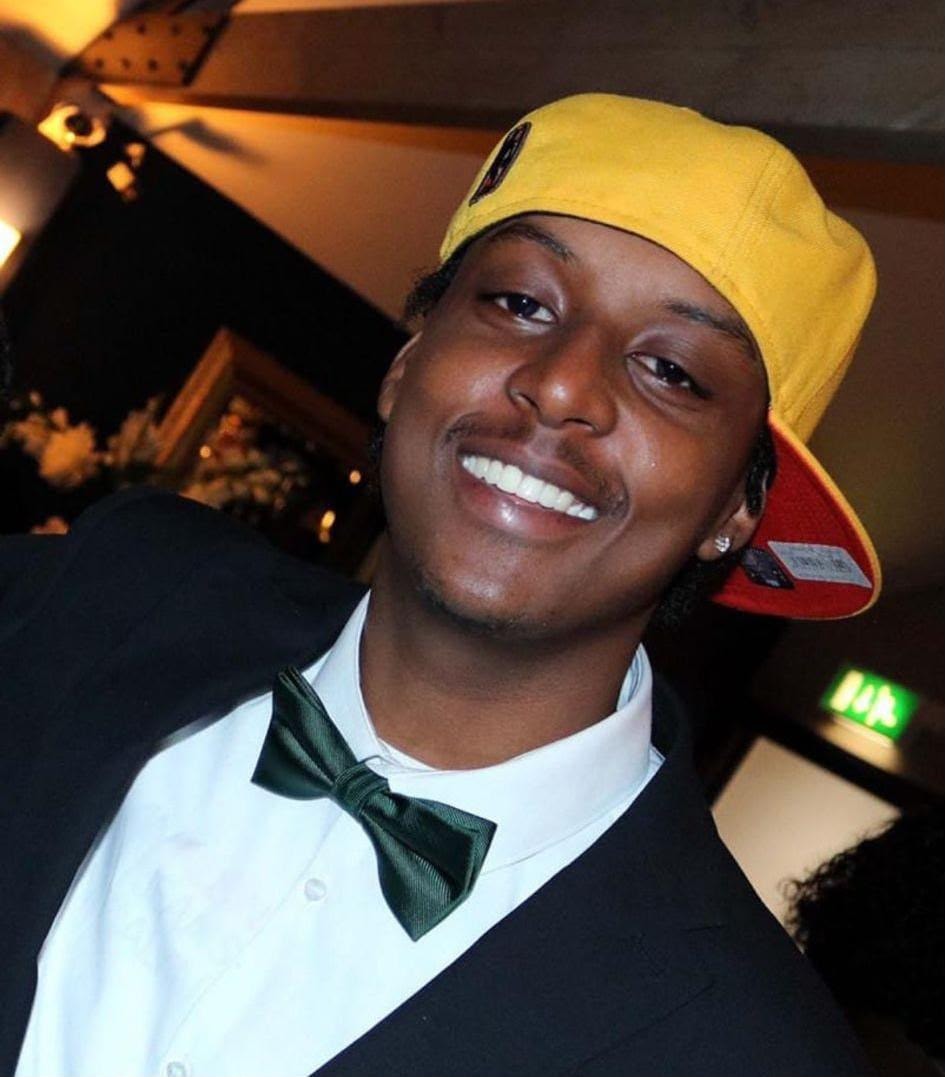 Eddie smiling in a yellow cap and green bow tie — always the King