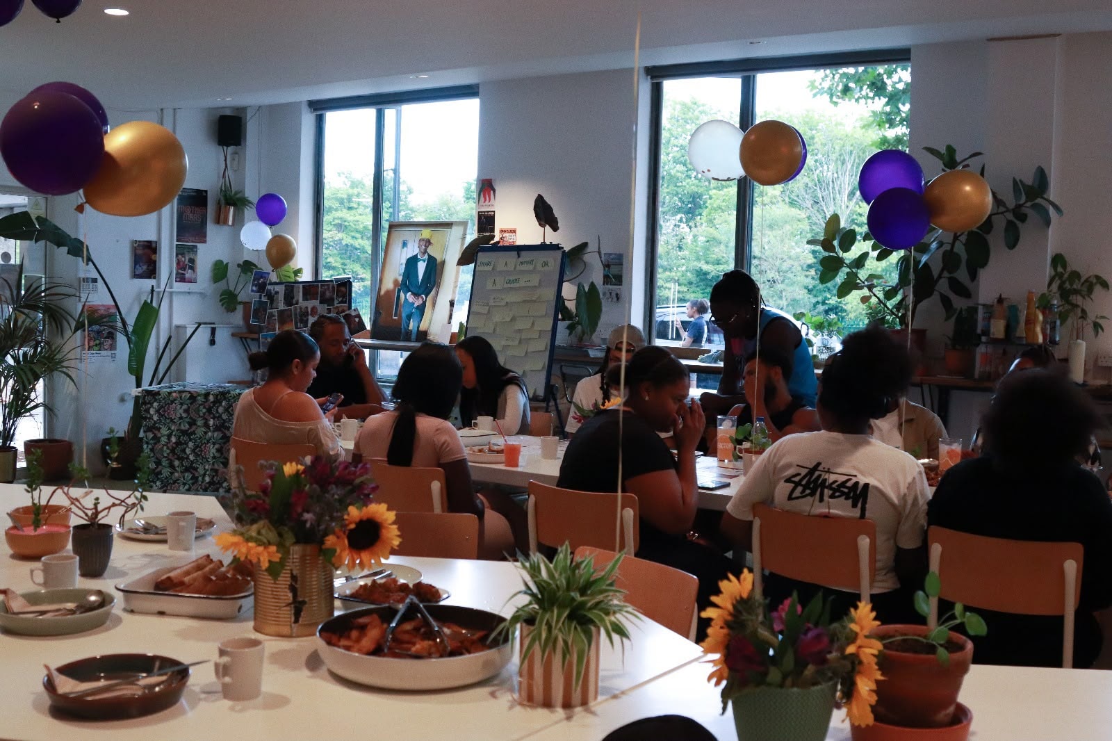 The full room at the EKing Foundation event — sunflowers, balloons and community