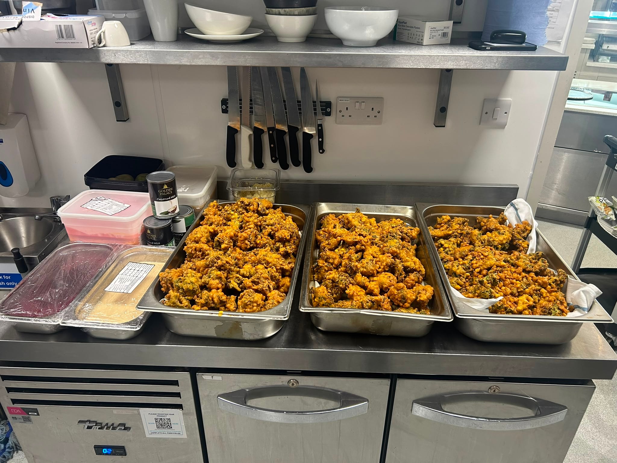 Three trays of golden fried food fresh from the kitchen