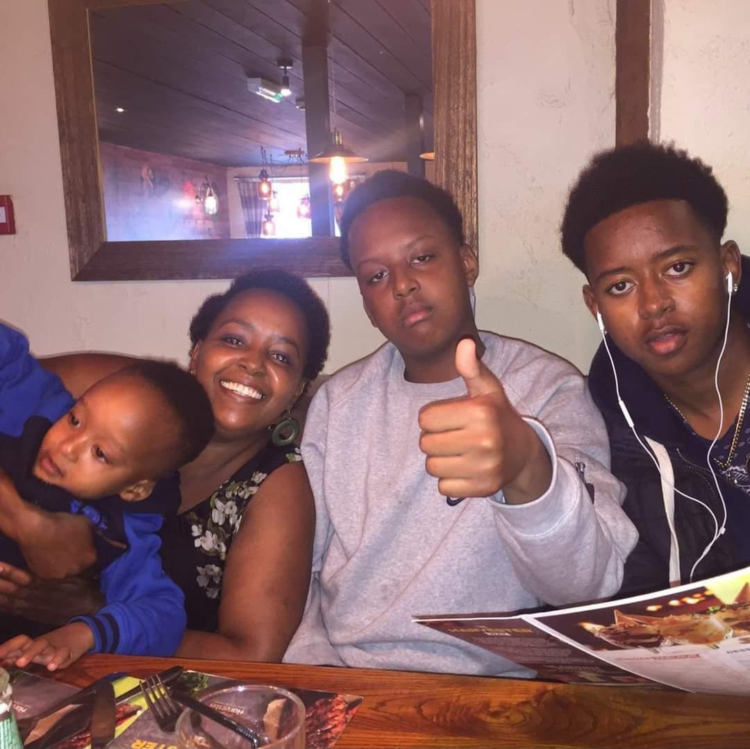 Eddie with his family at a restaurant, giving a thumbs up